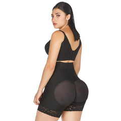 Black high-waist faja shorts worn by a model, rear view, showing the shaped padded seat panels and lace-trimmed hem